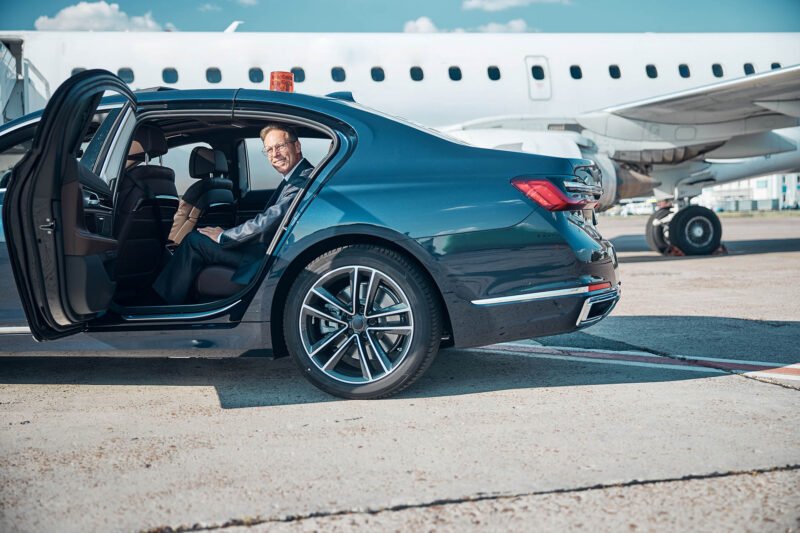 Passenger arriving at the airport beside a waiting taxi